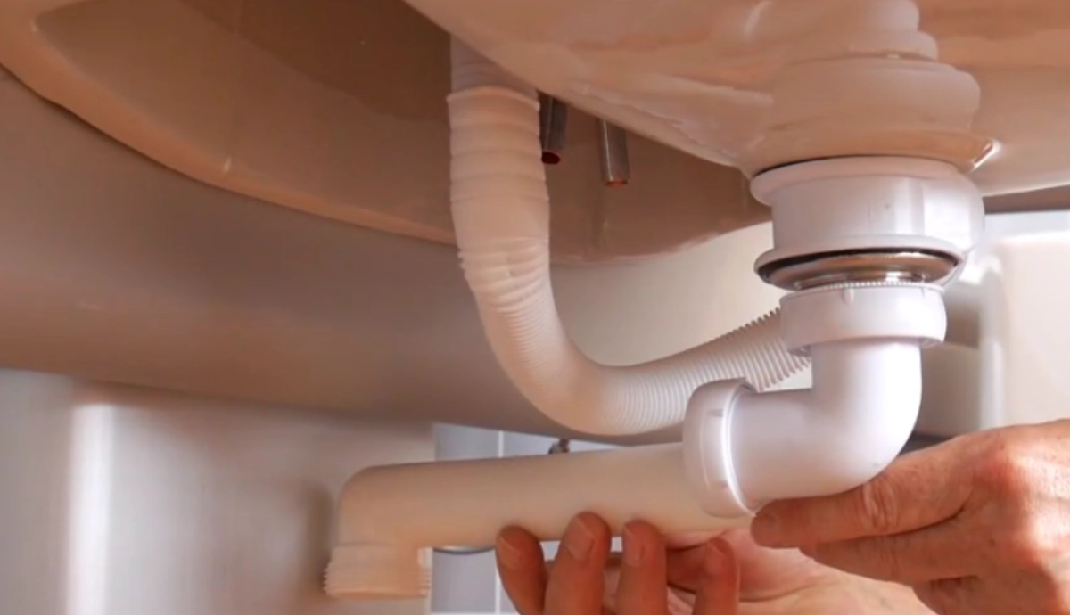 Flexible water feeds waste hoses and traps for a height adjustable washbasin