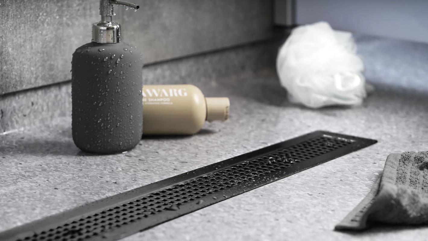 Purus linear channel drain spanning the width of a contemporary level access shower