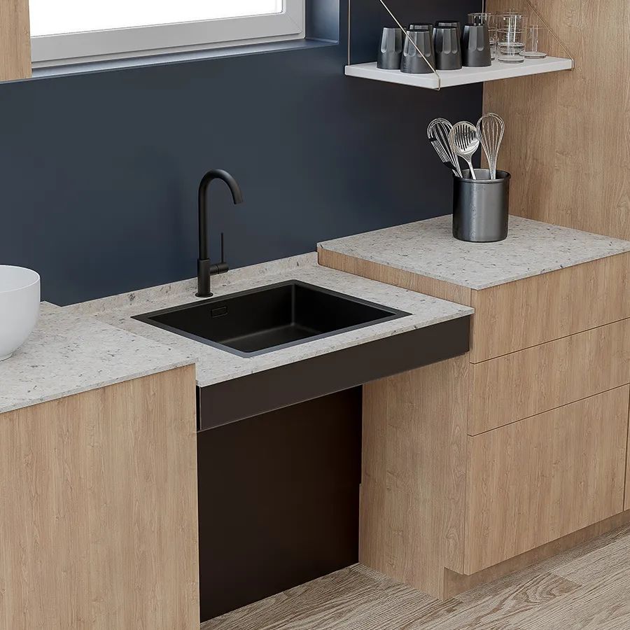 Height adjustable worktop being positioned for seated kitchen use