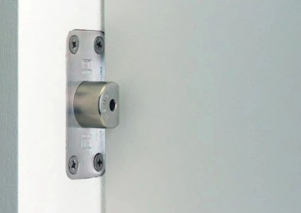 Stainless steel emergency release push-in door stop fitted to a door frame