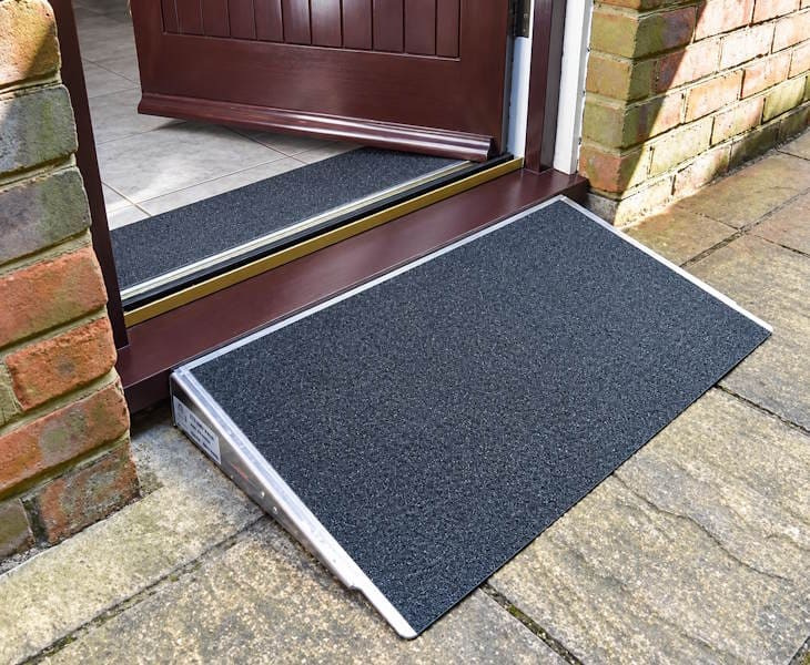 Door threshold ramp creating a smooth accessible route over a raised doorway